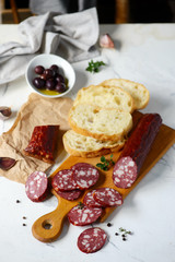 The cut salami sausage on a chopping board