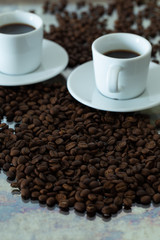 a cup of brewed coffee surrounded by whole unground beans
