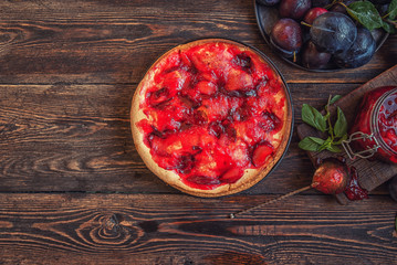 Homemade plum pie on the old wooden background. Healthy, organic food. Toned image.