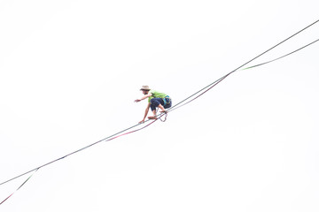 A man sits on a stretched sling on a white background.