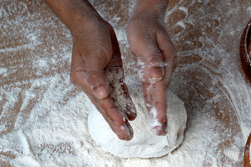 hand women clipping and sprinkling white flour on table