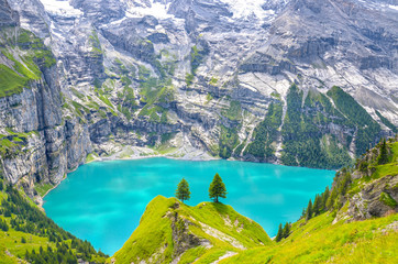 Beautiful top view of Oeschinensee, Oeschinen Lake by Kandersteg, Switzerland. Turquoise lake with steep mountains and rocks in background. Swiss Alps. Switzerland summer. Tourist destinations