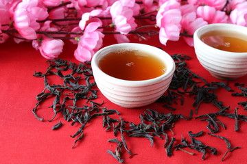 Chinese tea ceremony with the use of utensils of clay on the background of the cherry blossom.