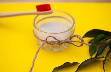 Wooden brushes, tooth powder, on a yellow background. Zero waste concept, close up.