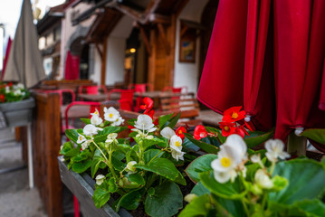 Picturesque alley in the old town Chamonix with plants and flowers. Cozy street with tables of cafe. Architecture and landmark. Cozy cityscape.