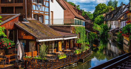 Fototapeta premium Tranquil canals with reflections in the pretty town of Colmar, Alsace, France. Stunning colorful ornamented facades in medieval Little Venice district
