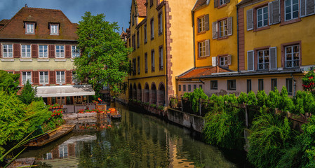 Fototapeta na wymiar View of the historic town of Colmar, also known as Little Venice, with tourists taking a boat ride along traditional colorful houses on idyllic river Lauch, Colmar, Alsace, France