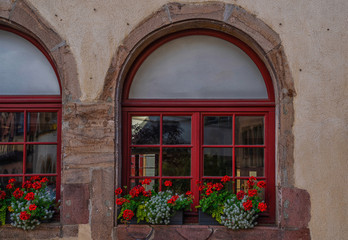Red window in Colmar, France. Beautiful red flowers at the windows.