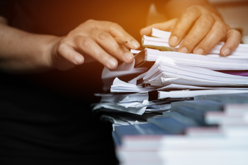 Business documents paperwork overwork concept : Employee people hands working in stacks paper files...