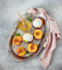 grilled peaches with a scoop of ice cream, honey on a light background