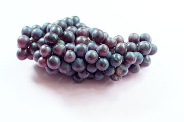 A claster of purple grapes on pink background