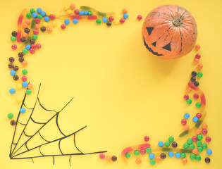 the concept of Halloween . orange pumpkin, colored sweets, candies