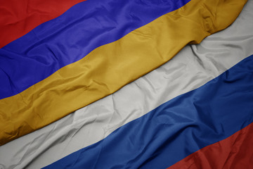 waving colorful flag of russia and national flag of armenia.