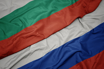 waving colorful flag of russia and national flag of bulgaria.
