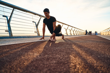 Young man doing exercise early in the morning on a pathway