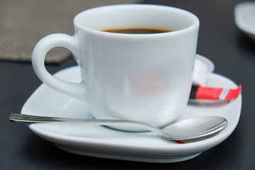 white espresso cup on a saucer with coffee spoon