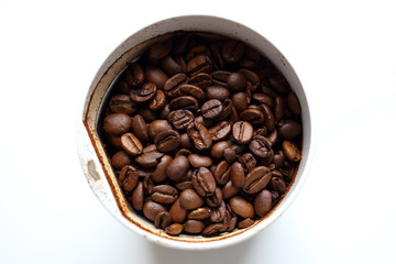 Freshly roasted fresh aromatic coffee beans in a coffee grinder on a white background, ground coffee, making coffee