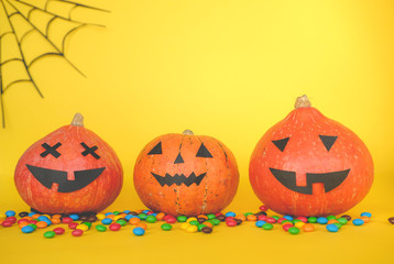 the concept of Halloween . orange pumpkin, colored sweets, candies