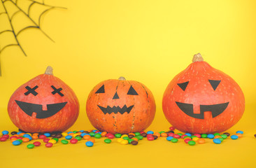 the concept of Halloween . orange pumpkin, colored sweets, candies