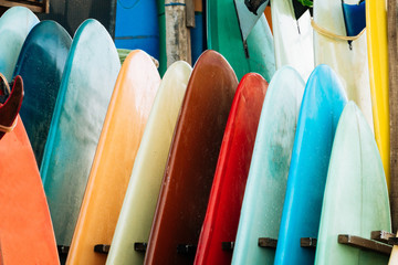 Close up Set of colorful surfboard for rent on the beach. Multicolored surf boards different sizes...