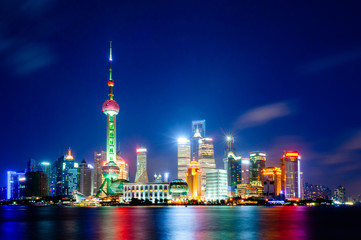 Shanghai. Night view of the financial district of the Pudong viewed from The Bund, with the light of buildings reflected on the Huangpu river