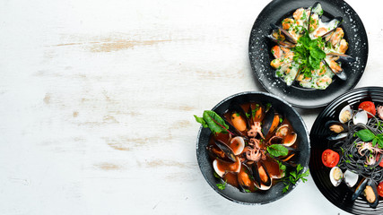 Dishes of seafood. Seafood on a plate. On a white wooden background. Top view. Free copy space.
