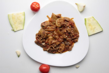Vegetable stew on white plate with tomato, garlic, onion, squash