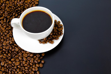 cup of coffee with beans on black background