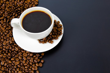 cup of coffee with beans on black background