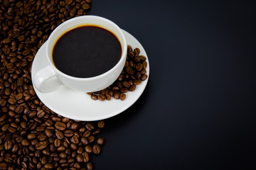 cup of coffee with beans on black background