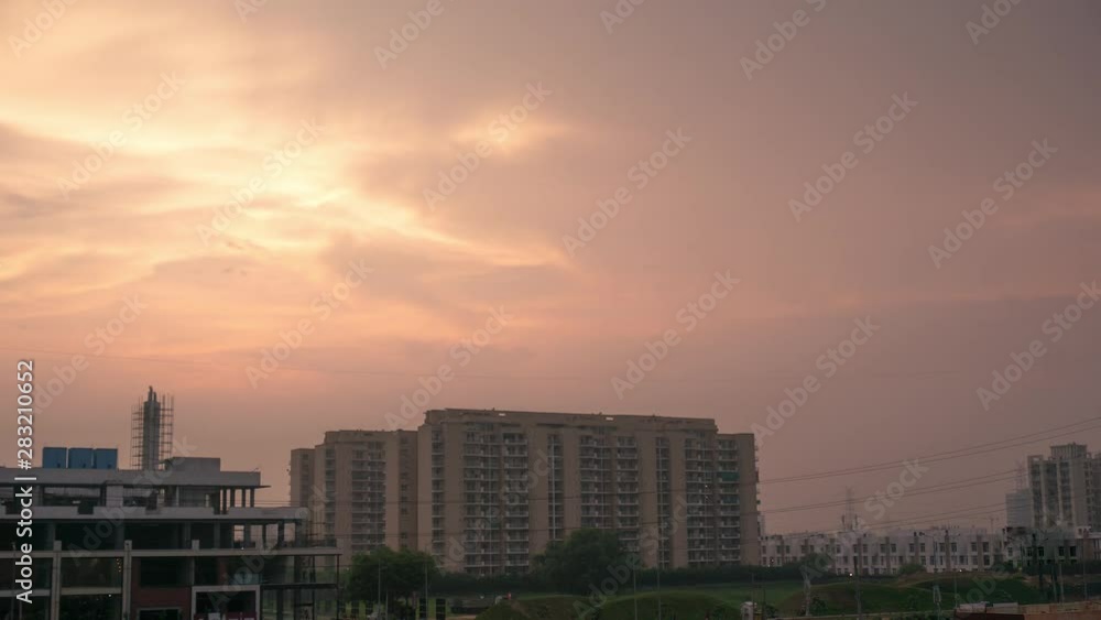 Wall mural timelapse of a monsoon evening sunset with apartment building exteriors and streets in gurgaon india