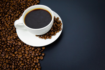 cup of coffee with beans on black background