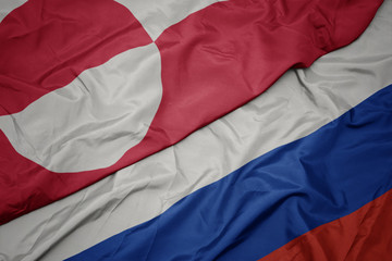 waving colorful flag of russia and national flag of greenland.