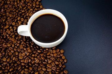 cup of coffee with beans on black background