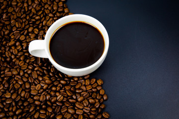 cup of coffee with beans on black background