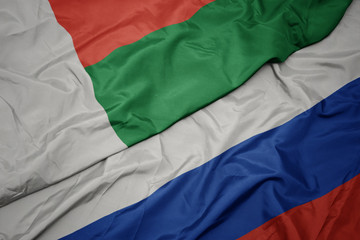 waving colorful flag of russia and national flag of madagascar.