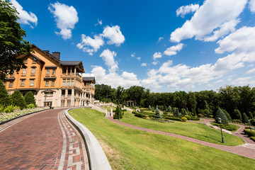 Walkway with paving stones near house and green grass
