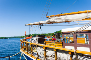 A large sailboat Brig stands on the pier at the pier and is loading to set sail