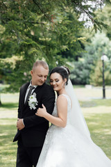 Amazing smiling wedding couple. Pretty bride and stylish groom. Beautiful couple bride and groom. Young wedding couple enjoying romantic moments outside city