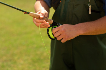 Fishing season. Close up of fisherman's hand with spinning