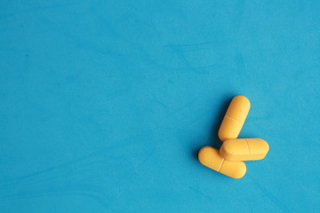 orange elongated pharmacy pills on colored background