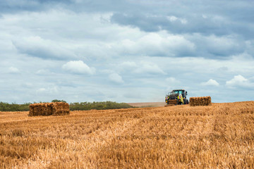 Obraz premium tractor and its trailer to make straw bales