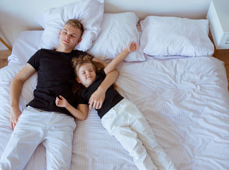 caucasian siblings - teenager boy brother and little girl sister in bedroom modern loft interior....