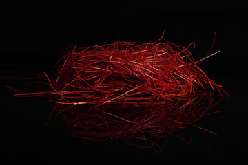 Fototapeta premium Lot of whole red chili pepper threads isolated on black glass