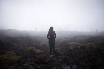 Young woman contemplating the fog on her way to Teide top in Tenerife, Spain