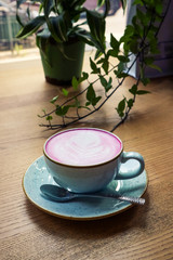 Cup of pink cappuccino in blue cup