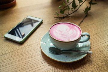 Cup of pink cappuccino in blue cup