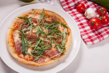 Close up of Pizza with prosciutto (parma ham) and  arugula (salad rocket). Vegetables