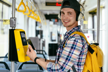 Everyday life and commuting to work or study by bus tram concept. Handsome student man with...