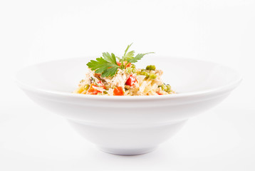 Spaghetti with cream sauce with smoked mackerel, peas ,bell pepper and some parsley on a white plate on a white background